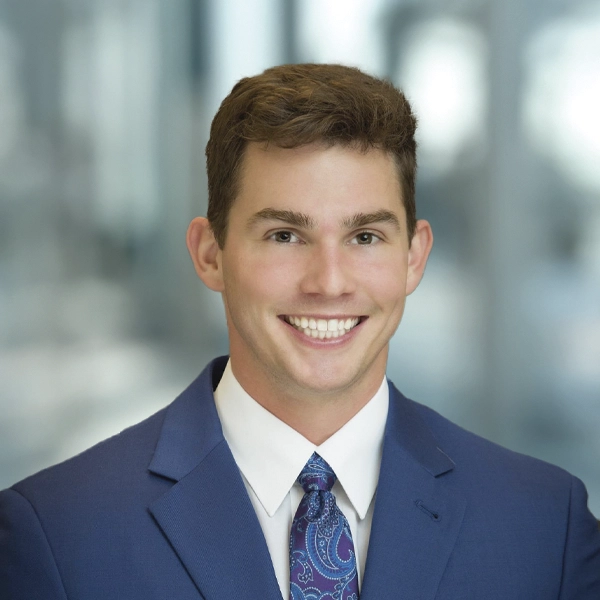 A headshot of Dr. Trevor Inman a chiropractor in Precision Spine & Sport with blue background
